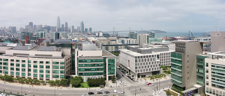 A landscape view of UCSF Mission Bay, which is a teaching, research and clinical care campus. Downtown San Francisco is shown in the background.